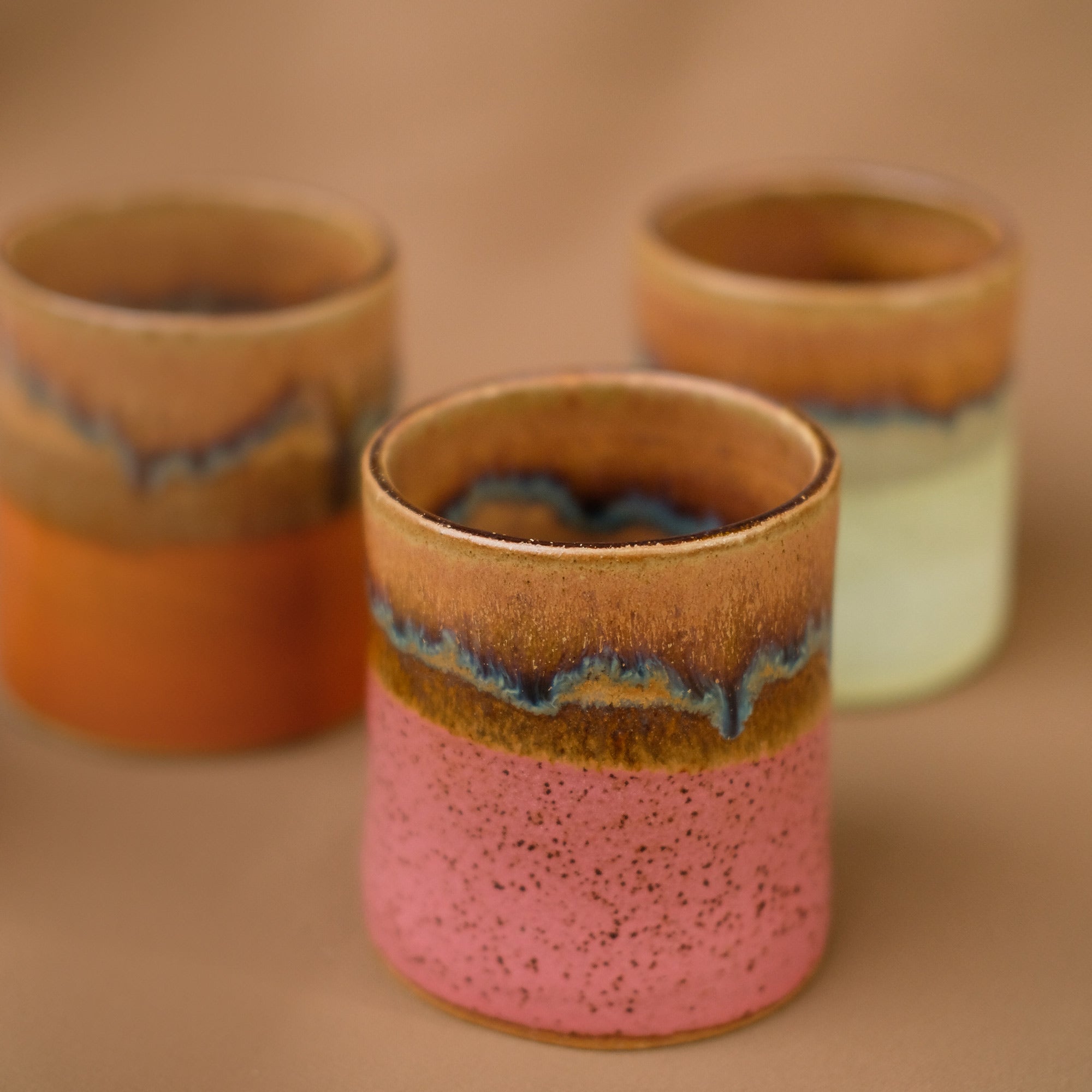 Gelber, mattierter und brauner Keramikbecher